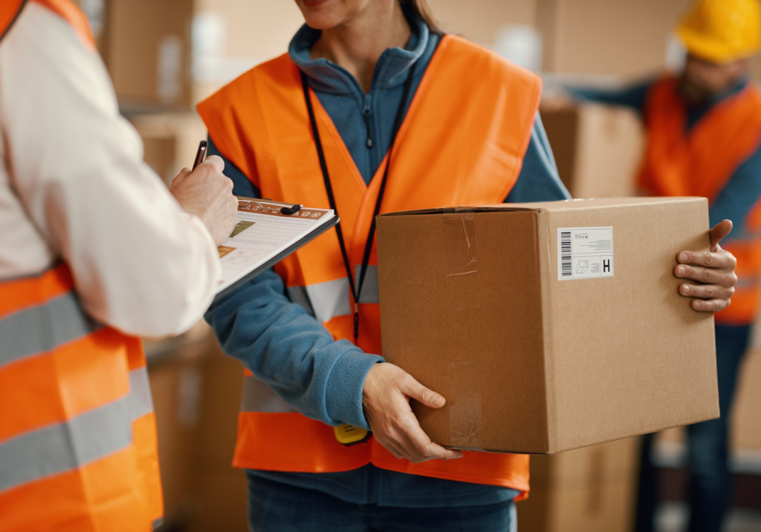 Warehouse workers handling and checking packages.